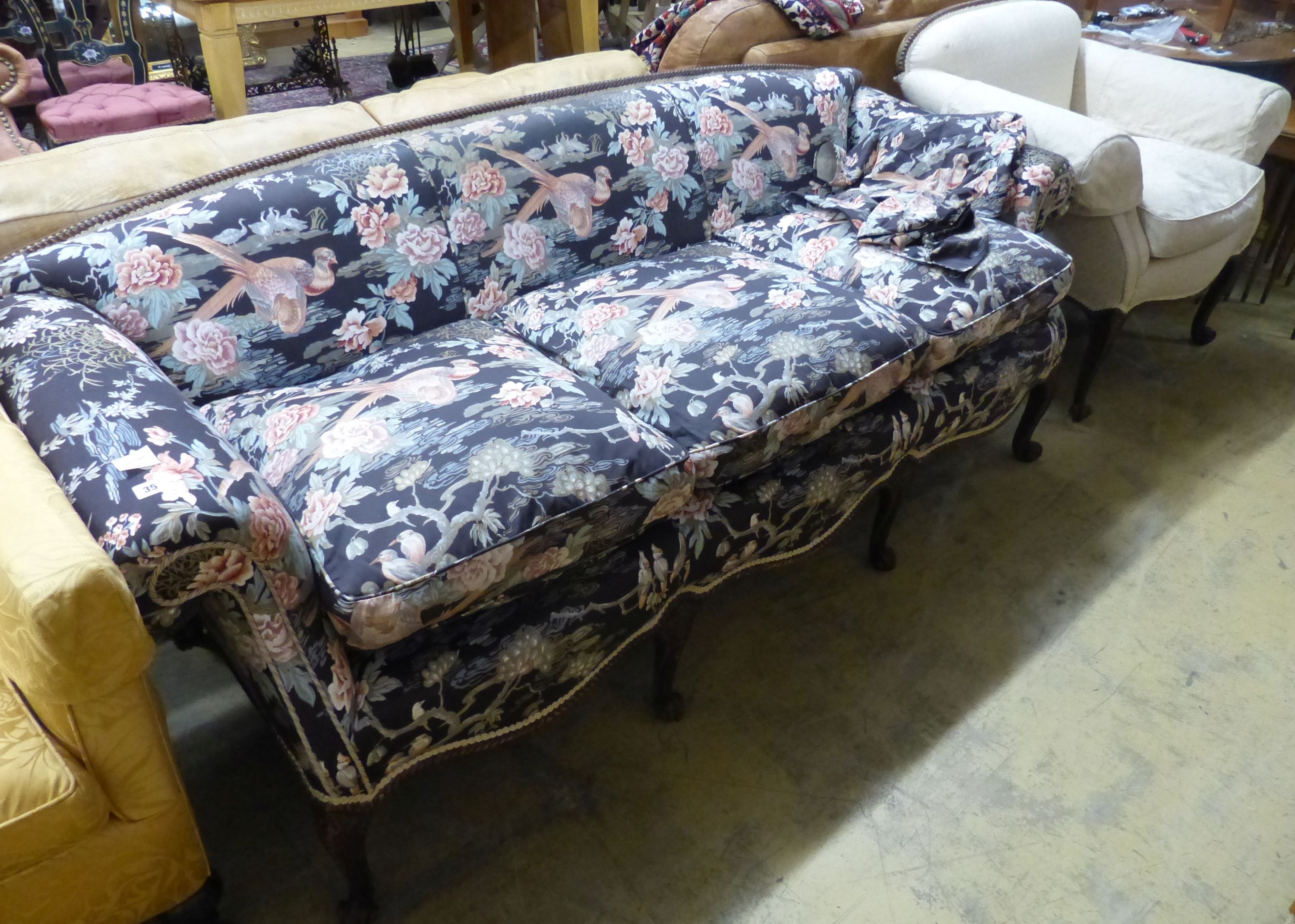 A late 19th century Continental mahogany scroll arm sofa and armchair, sofa upholstered in a floral fabric, on carved cabriole legs W 200 D 86 H 81 cms